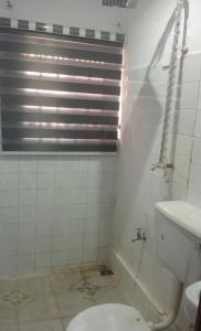 a bathroom with a toilet and a shower and a sink at Monarch Appartement in Oshogbo +12 photos
