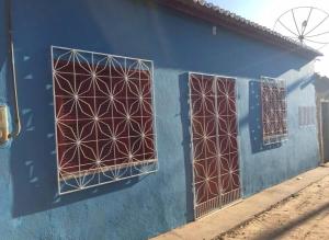 two doors on a blue building with geometric designs on it at Casinha de vó in Aracati