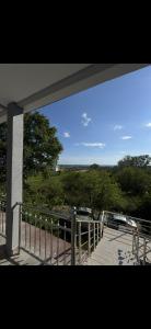 a balcony with a view of the water and trees at Hotel Dalian in Baks-Rrjoll