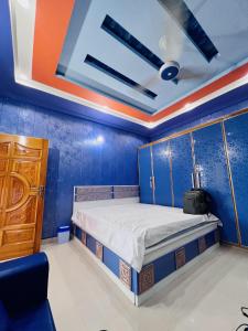 a bedroom with a bed and a blue wall at umer cottage in Murree