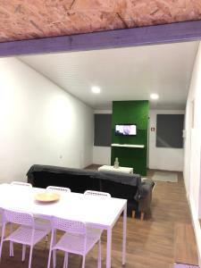 a living room with white tables and a green wall at Sky carvoeiro in Mação