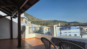 a balcony with a table and chairs and a view at Indigo House in Chefchaouen