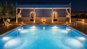 a large swimming pool in front of a house at night at Villa El Houda in Souk el Had du Drâa
