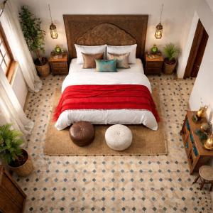 a bedroom with a large bed with a red blanket at Villa El Houda in Souk el Had du Drâa