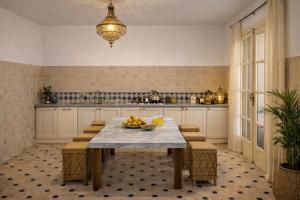 a kitchen with a table with a bowl of fruit on it at Villa El Houda in Souk el Had du Drâa