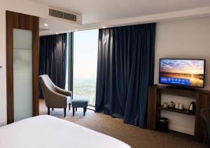 a hotel room with a bed and a television at Hampton by Hilton Dundee City Centre in Dundee