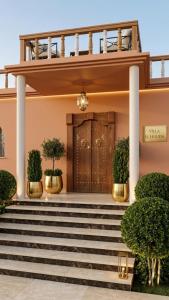 a front door of a building with stairs and plants at Villa El Houda in Souk el Had du Drâa +4 photos