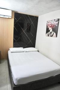 a bed in a room with a black and white wall at Hotel Lua Origenes Rodadero, Santa Marta in Santa Marta +2 photos