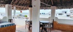 a bar with tables and chairs and a view of the ocean at Lola House in Lamu