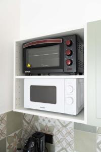 a microwave oven sitting on top of a shelf at Brighella in Putignano