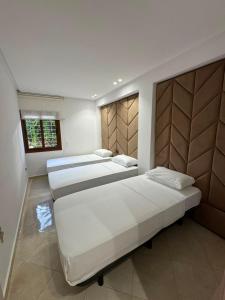 a bedroom with three beds and a window at Studio marina smir in Marina Smir