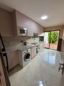 a kitchen with a washing machine and a microwave at Studio marina smir in Marina Smir