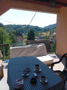 a table with cups and saucers on a balcony at Ljiljana Apartman 1 in Rakari