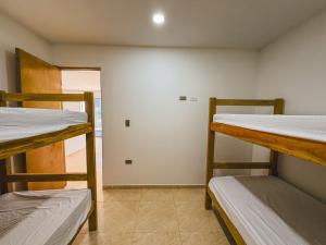 a room with three bunk beds and a hallway at El Viento Beach Apartamentos in San Bernardo del Viento