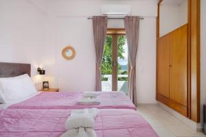 a bedroom with a large pink bed with a window at Dionysus House Lasithi Plateau in Magoulás