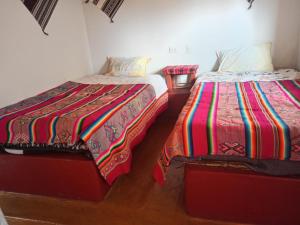 two beds sitting next to each other in a room at Casa de Ruben - Lac Titicaca in Llachon