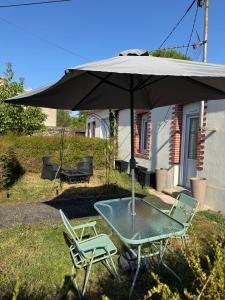 a table and two chairs under an umbrella at La Folie Blanche in Vertou