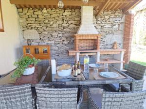 a patio with a table with chairs and a stove at Lar de Mamita in Cristiñade