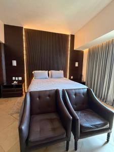a bedroom with a bed and a leather couch at Tropical Executive Confort in Manaus