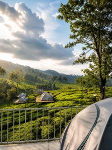 a tent with a view of a field and mountains at Skydeck - Boche 1000 Acre in Meppādi