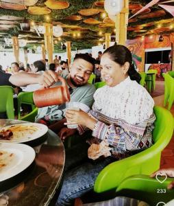 a man and woman sitting at a table in a restaurant at Skydeck - Boche 1000 Acre in Meppādi