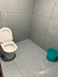 a bathroom with a toilet and a blue bucket at Skydeck - Boche 1000 Acre in Meppādi