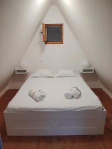 a bedroom with a white bed with towels on it at Bungalov A in Sveti Filip i Jakov