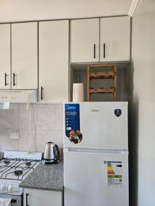 a white refrigerator in a kitchen with white cabinets at NAT home in San Lorenzo