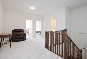 a living room with a staircase and a chair at Modern Luxury Townhouse in Cambridge