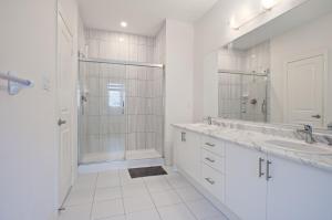 a white bathroom with two sinks and a shower at Modern Luxury Townhouse in Cambridge +43 photos