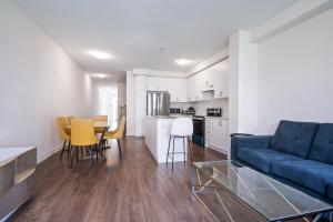 a living room with a blue couch and a kitchen at Modern Luxury Townhouse in Cambridge