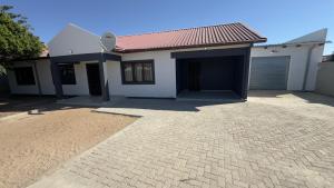 a house with a brick driveway in front of it at River Gates Home in Rundu