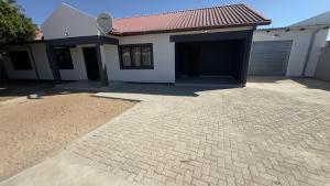 a house with a brick driveway in front of a garage at River Gates Home in Rundu +6 photos