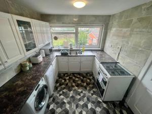 a small kitchen with a sink and a dishwasher at Large river side house, parking,for 9 people in Bedford