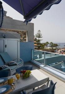 a table with a bowl of fruit on a balcony at HolaMogamar in Puerto de Mogán