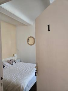 a bedroom with a white bed and a door at L'argonnière in Buzancy