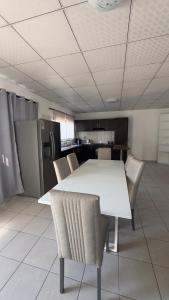 a white table and chairs in a room at River Gates Home in Rundu