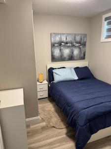 a bedroom with a bed and a painting on the wall at The Cozy Nook in Cochrane