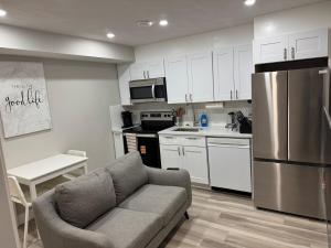 a living room with a couch and a kitchen at The Cozy Nook in Cochrane