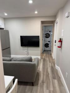 a living room with a couch and a flat screen tv at The Cozy Nook in Cochrane