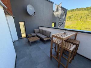a patio with a couch and a table and chairs at Moselpanorama91 in Briedel