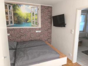 a bedroom with a brick wall and a bed with a window at Willy und Gudrun in Rheda-Wiedenbrück