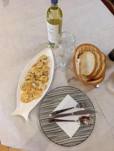 a table with a plate of food and a bottle of wine at Jasmine Apartments in Velipojë +27 photos