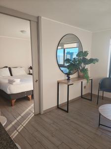 a bedroom with a bed and a table with a mirror at VIP Suite Antofagasta in Antofagasta +10 photos