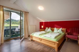 a bedroom with a bed and a red wall at Wellness Ferienwohnung mit Hallenbad und Sauna in Oberaudorf +11 photos