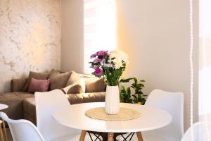 a white table with a vase of flowers on it at Lighthouse Kotor in Prčanj