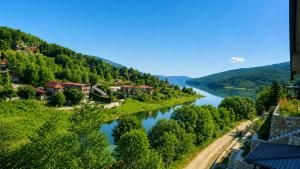 a river in a valley with houses and trees at Agel Inn Apartments Mavrovo in Mavrovo