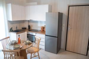 a kitchen with a table and a refrigerator at Boho Nook Apartment in Rethymno