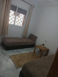 a small room with two beds and a window at Dardyafa in Larache