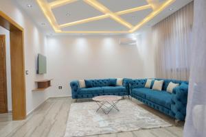 a living room with a blue couch and a table at Villa Ghizen in Fafou